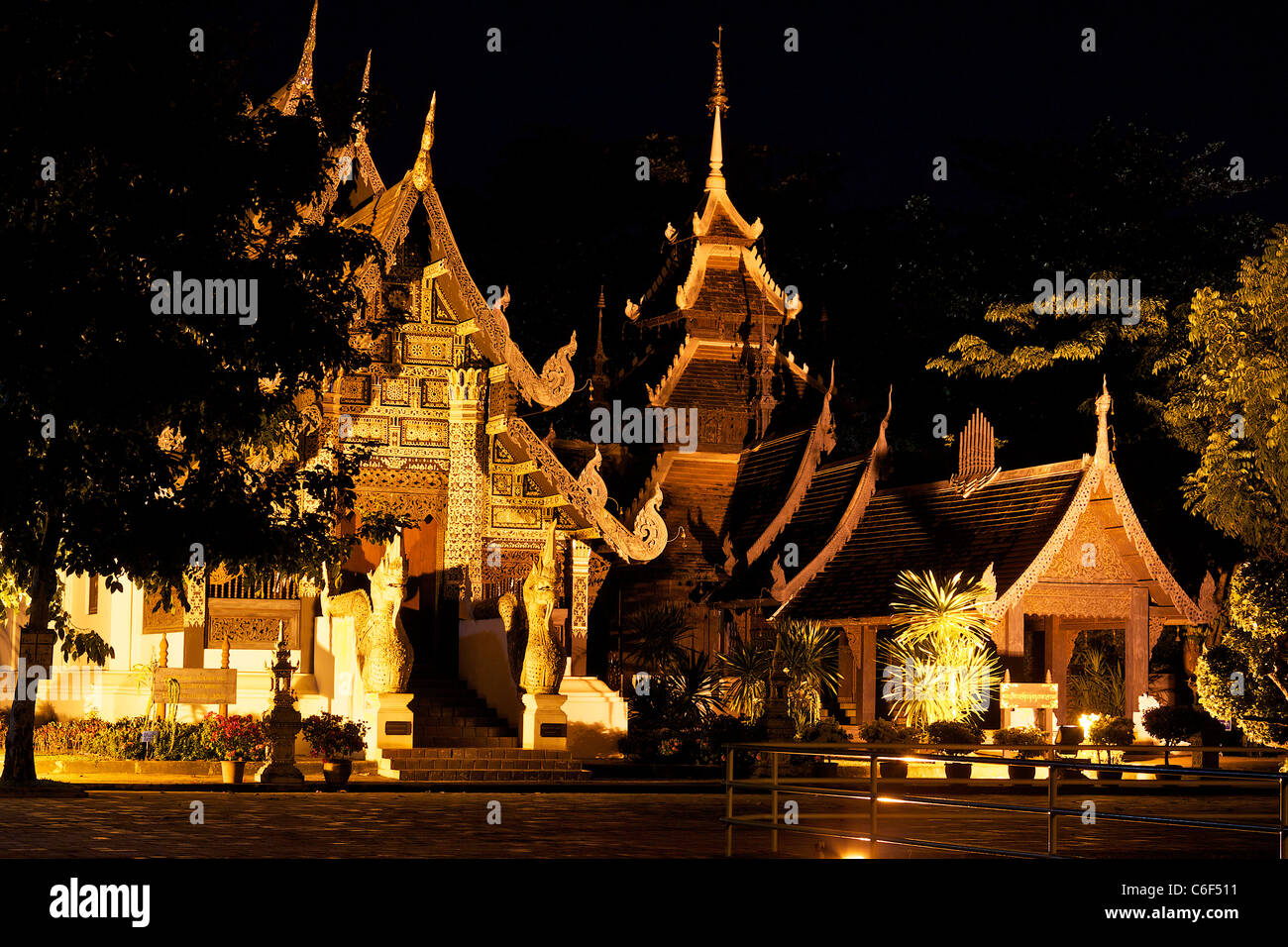 Illuminato tempio in legno edifici nella motivazione del Wat Chedi Luang Wora Wiharn, costruita nel 1401, in Chiang Mai Foto Stock