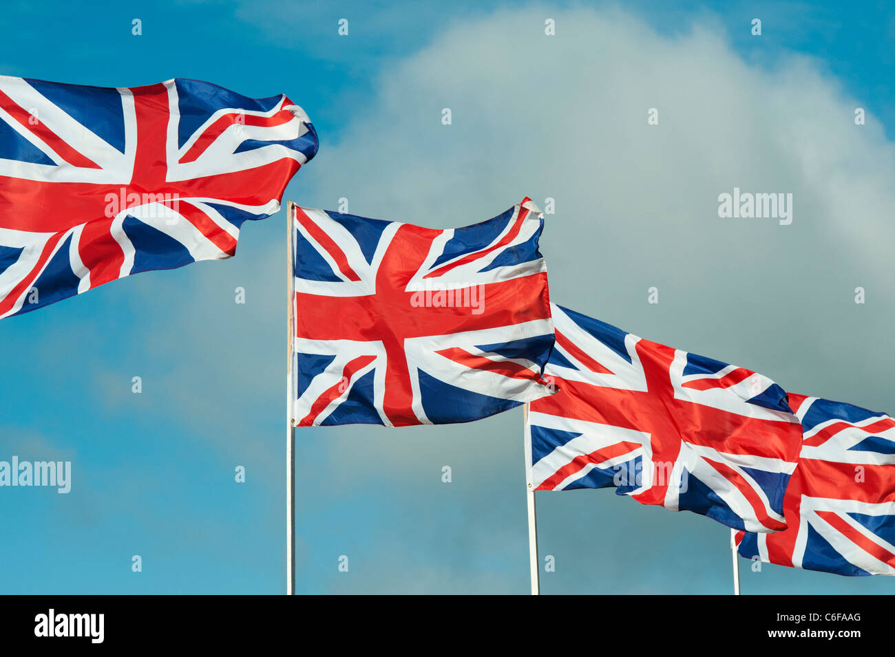 Quattro Union Jack Flag sbattimenti nel vento contro un cielo blu Foto Stock