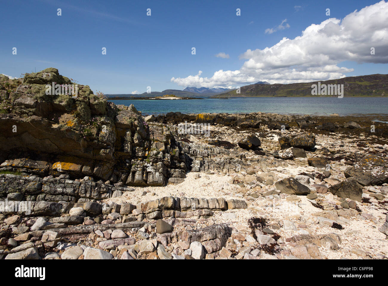 Costa rocciosa vicino a ORD con il Loch Eishort con Nero montagne Cuillin sull'orizzonte, Ord, Isola di Skye, Scotland, Regno Unito Foto Stock