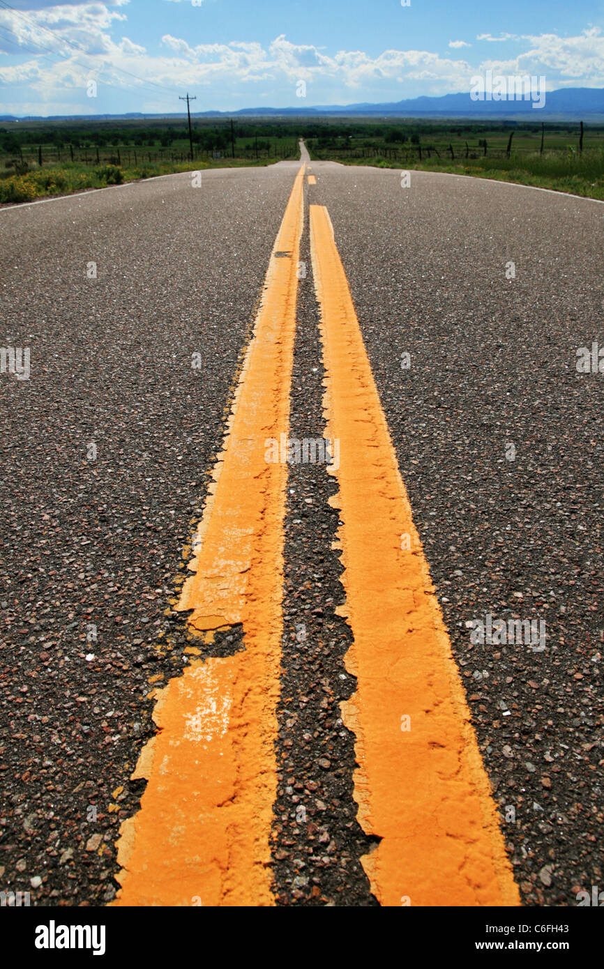 Le linee gialle su una strada rurale voce in distanza Foto Stock