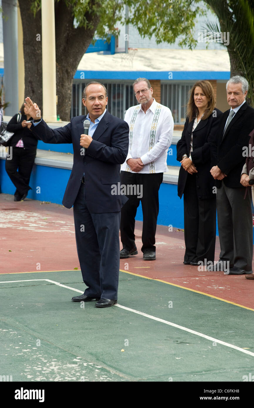 Presidente Calderon affrontare gli studenti di una scuola in Morelia come sua moglie e Peter Greenberg a guardare. Foto Stock