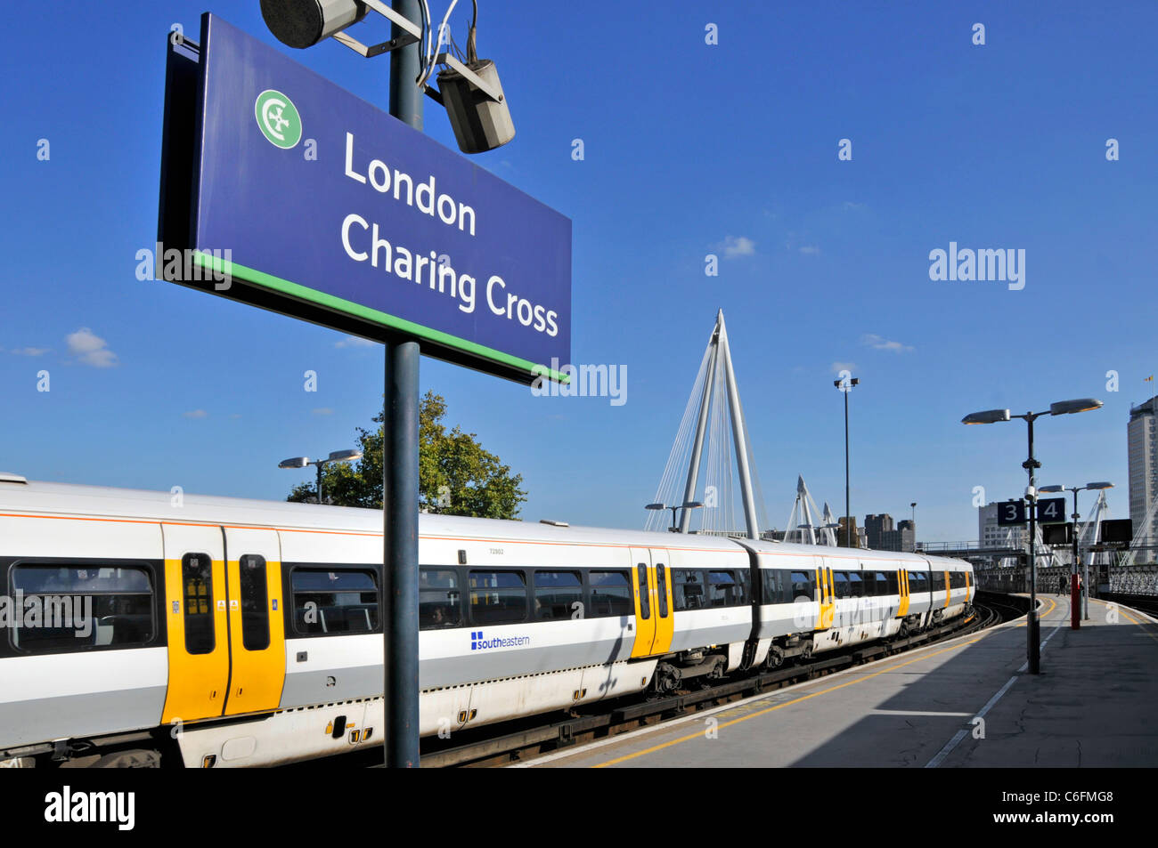 Indicazioni per la stazione ferroviaria di Charing Cross con i mezzi pubblici verso sud Carrozze ferroviarie per passeggeri orientali su una piattaforma su un cielo blu Giorno a Londra Inghilterra Regno Unito Foto Stock