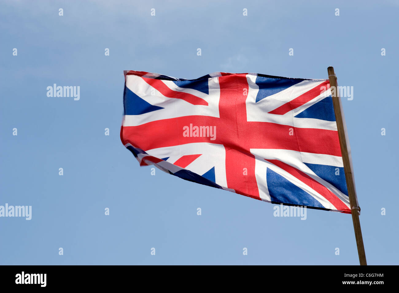 Union Jack flag battenti contro un cielo blu Foto Stock