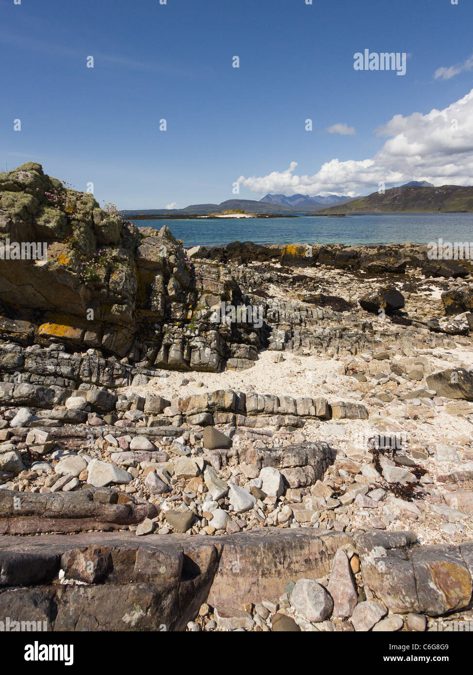 Costa rocciosa vicino a ORD con il Loch Eishort con Nero montagne Cuillin sull'orizzonte, Ord, Isola di Skye, Scotland, Regno Unito Foto Stock