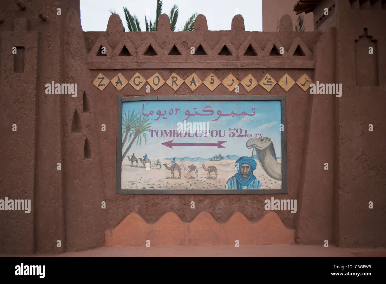 Cartello stradale per Tombouctou '52 giorni da camel' sul bordo del villaggio di Zagora, sud del Marocco Foto Stock