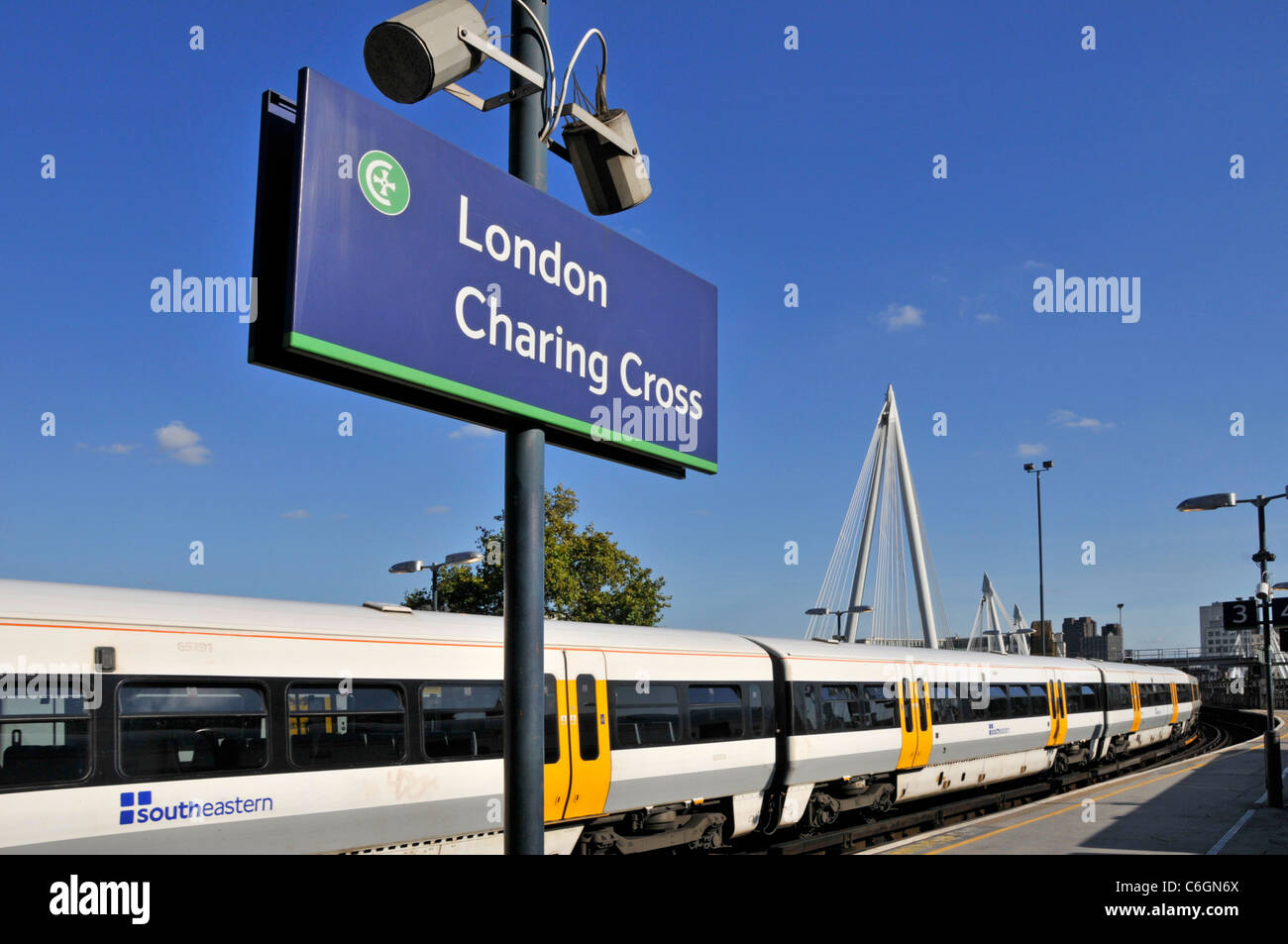 Indicazioni per la stazione ferroviaria di Charing Cross con i mezzi pubblici verso sud Carrozze ferroviarie per passeggeri orientali su una piattaforma su un cielo blu Giorno a Londra Inghilterra Regno Unito Foto Stock