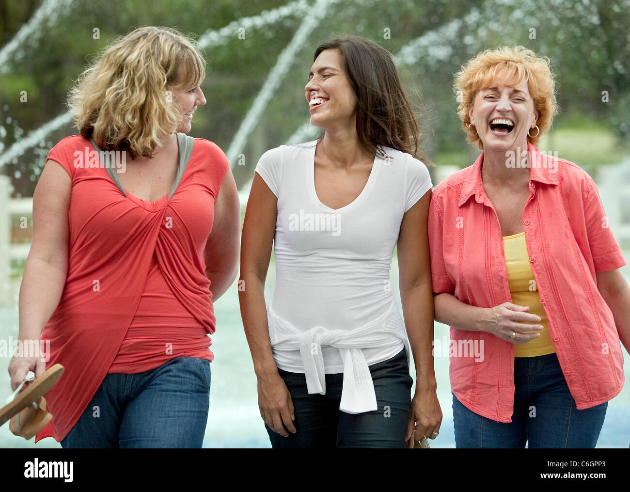 Tre donne divertirsi in un parco locale con una passeggiata a piedi per promuovere un attivo uno stile di vita sano. Foto Stock