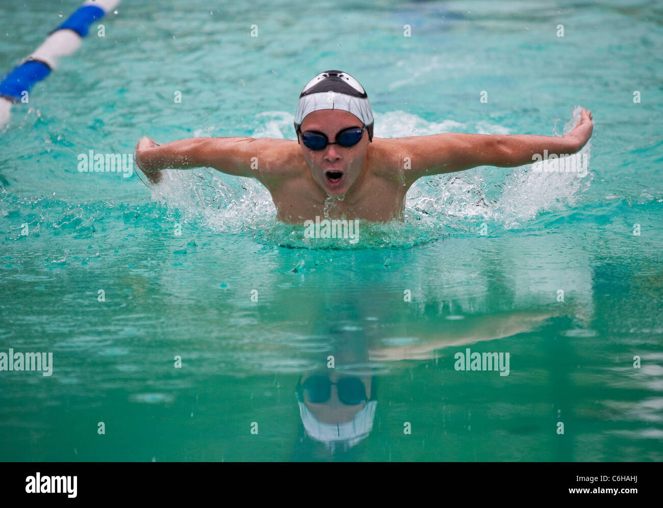 Ragazzo adolescente nuoto gara a farfalla a scuola gala Foto Stock