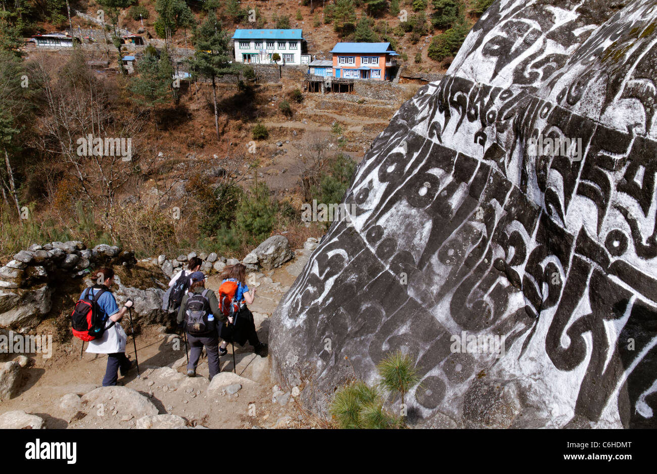 Trekking a piedi passato scolpito in pietra di mani nella regione dell Everest, Nepal Foto Stock