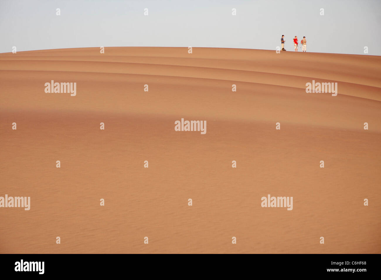 Tre escursionisti sulla sommità di una grande duna Foto Stock