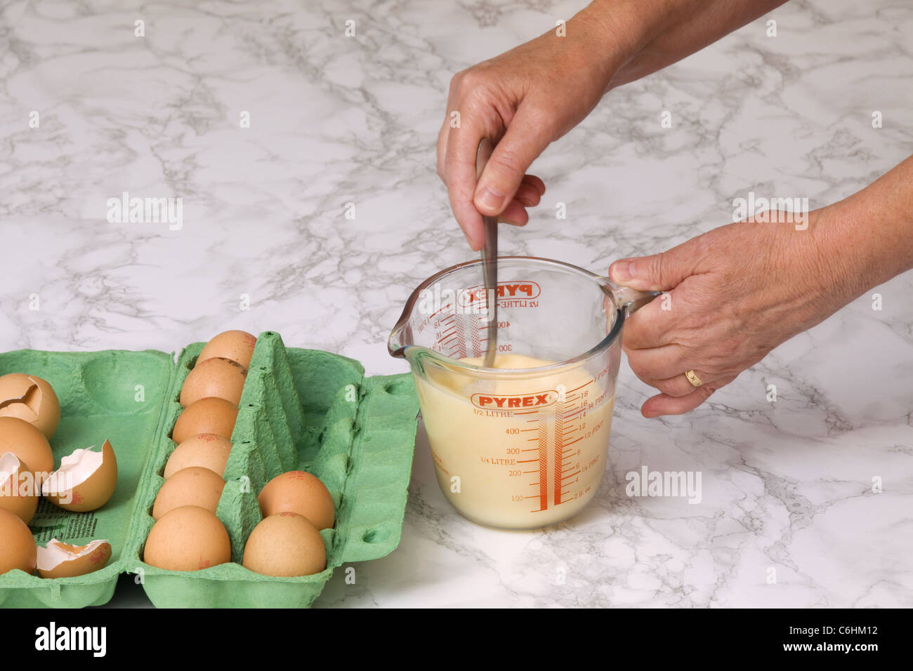 Si vede una donna che mescola le uova con il latte Foto Stock