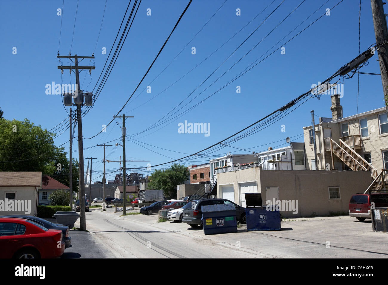 Locale di energia elettrica le linee di alimentazione e di distribuzione nel vicolo di negozi e case nel quartiere francese winnipeg Manitoba Canada Foto Stock