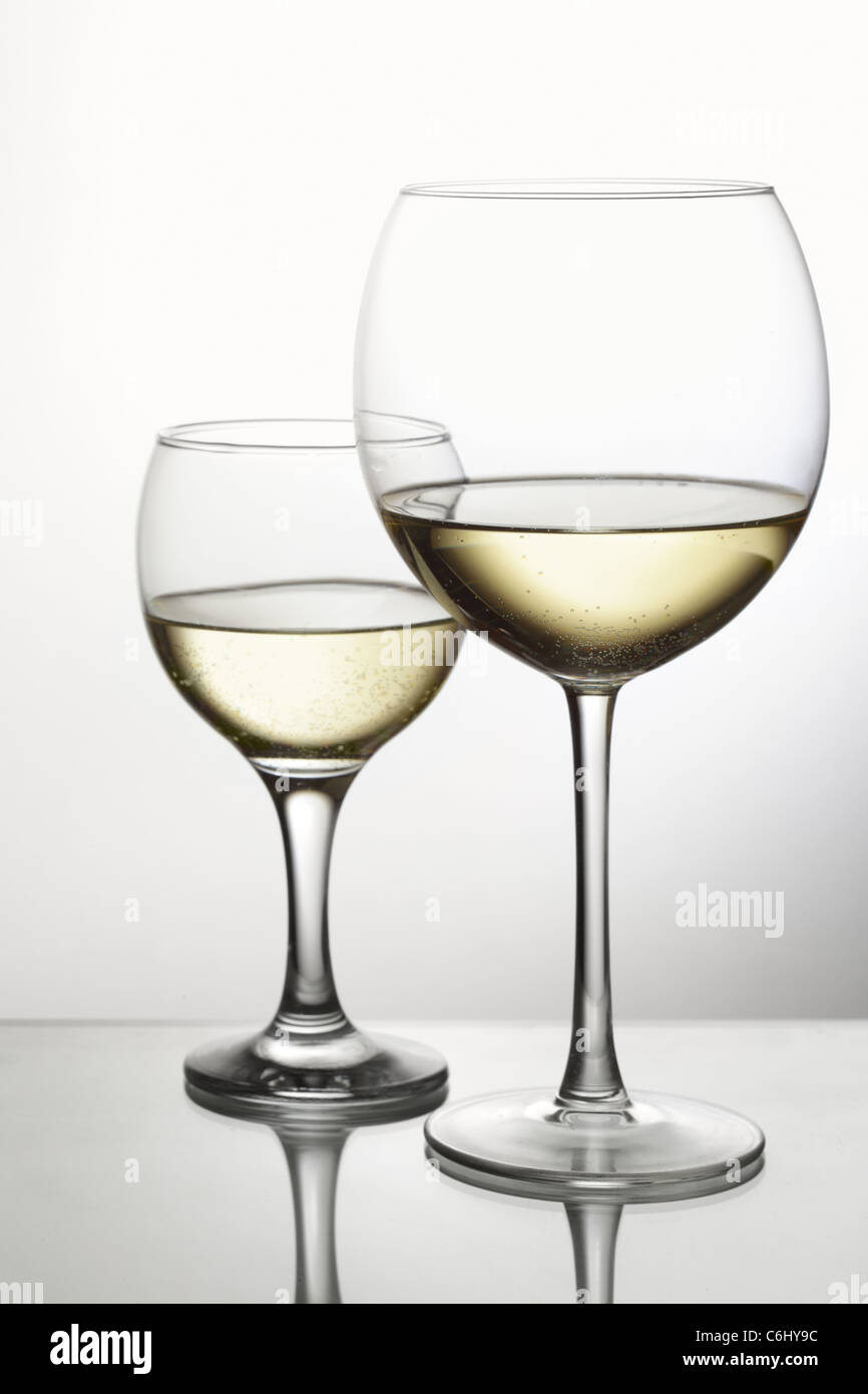 Due bicchieri di vino bianco su sfondo grigio chiaro Foto Stock