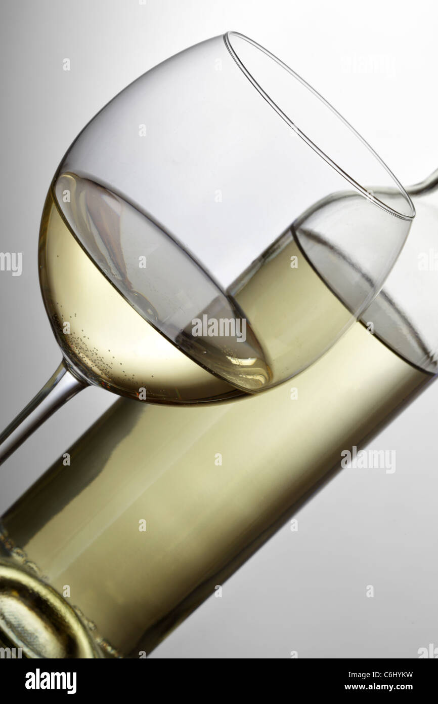 Bottiglia di vino bianco e vetro su sfondo grigio chiaro Foto Stock