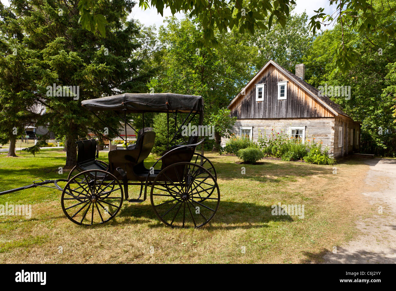 Un vecchio buggy e uno storico mennonita home al mennonita Heritage Village in Steinbach, Manitoba, Canada. Foto Stock