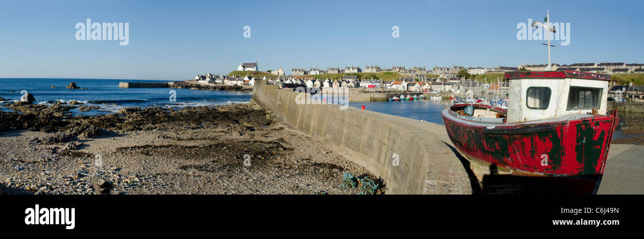Vista panoramica del Molo Ovest in Findochty Harbour con la vecchia barca rossa - Moray Coast Foto Stock