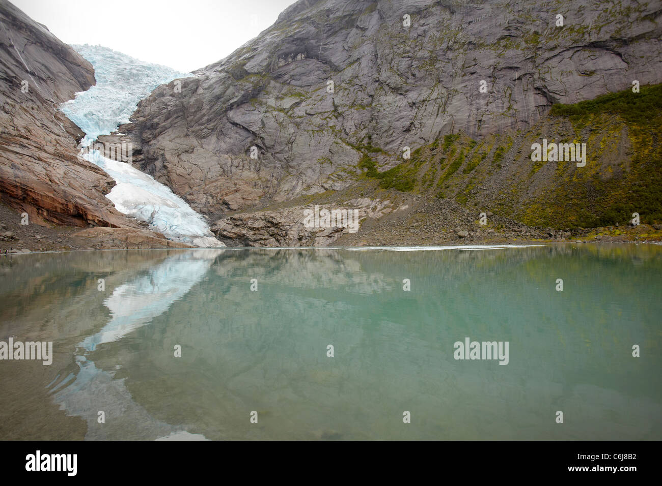 Il Ghiacciaio Briksdal, Valle anticato, Norvegia, con il lago glaciale Briksdalbrevatnet in primo piano Foto Stock