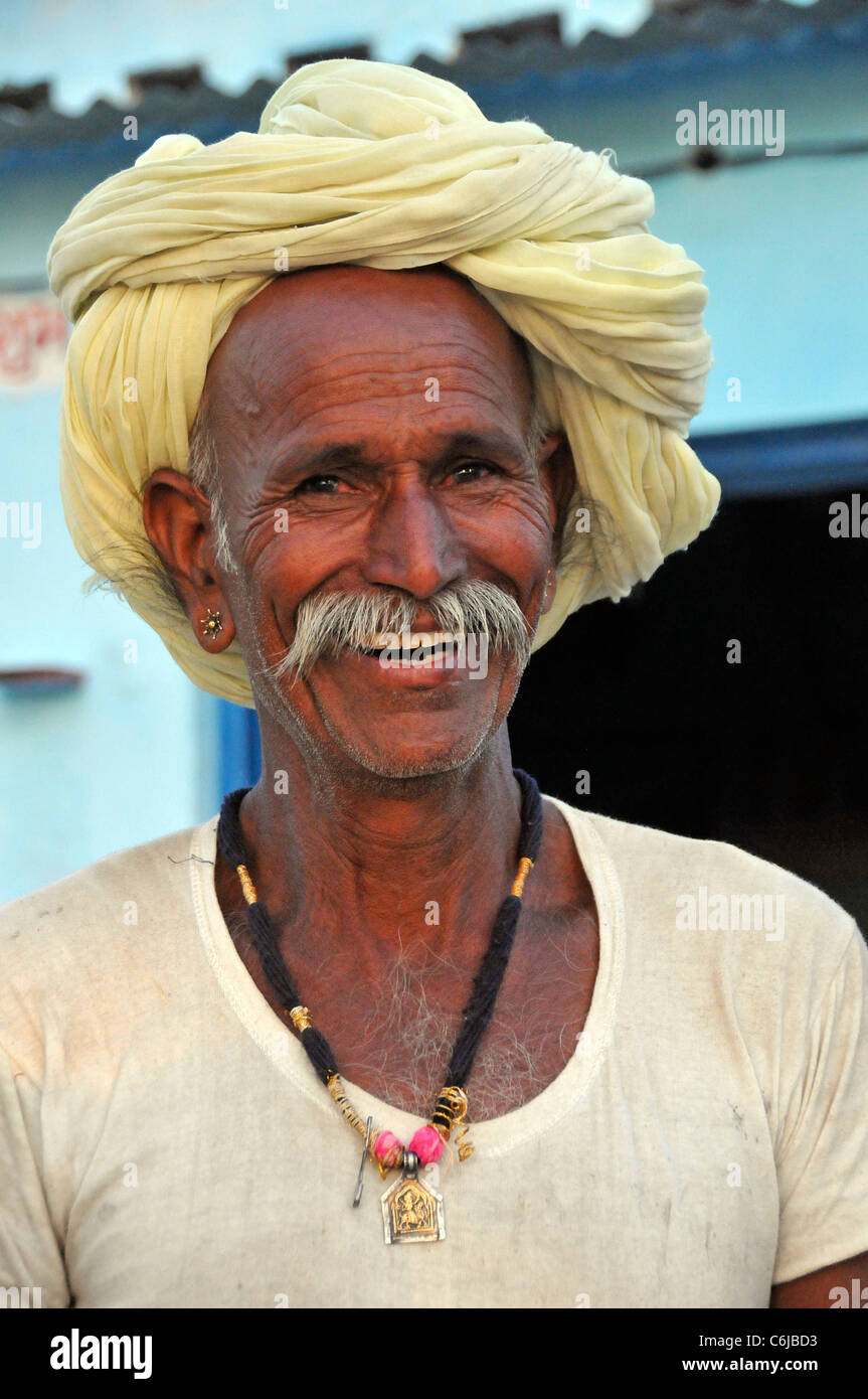 Ritratto di un uomo tribale in turbante giallo Colli Aravalli Rajasthan in India Foto Stock