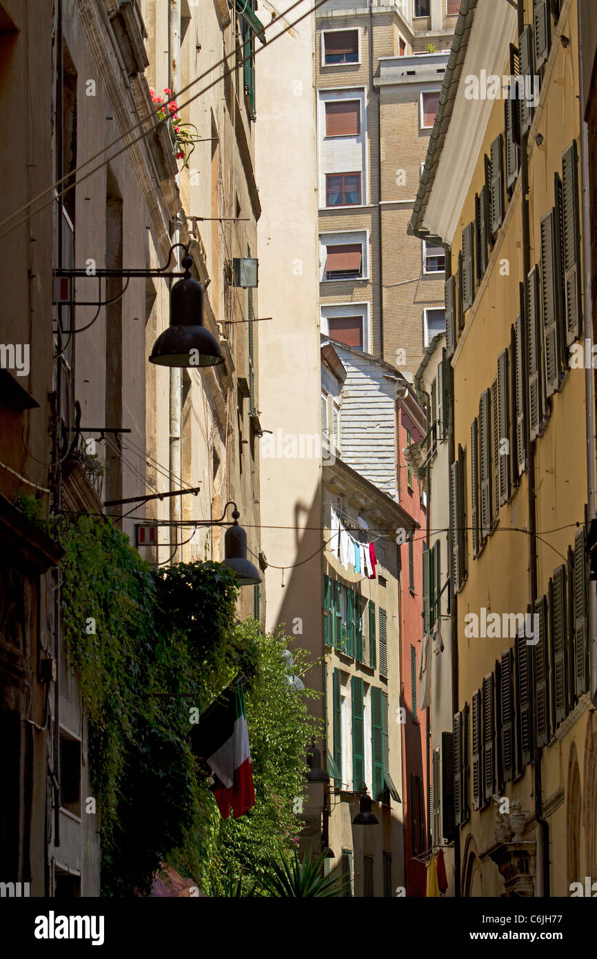 Uno stretto vicolo buio e la strada nel centro di Savona Italia. Edifici vecchi e business. Foto Stock
