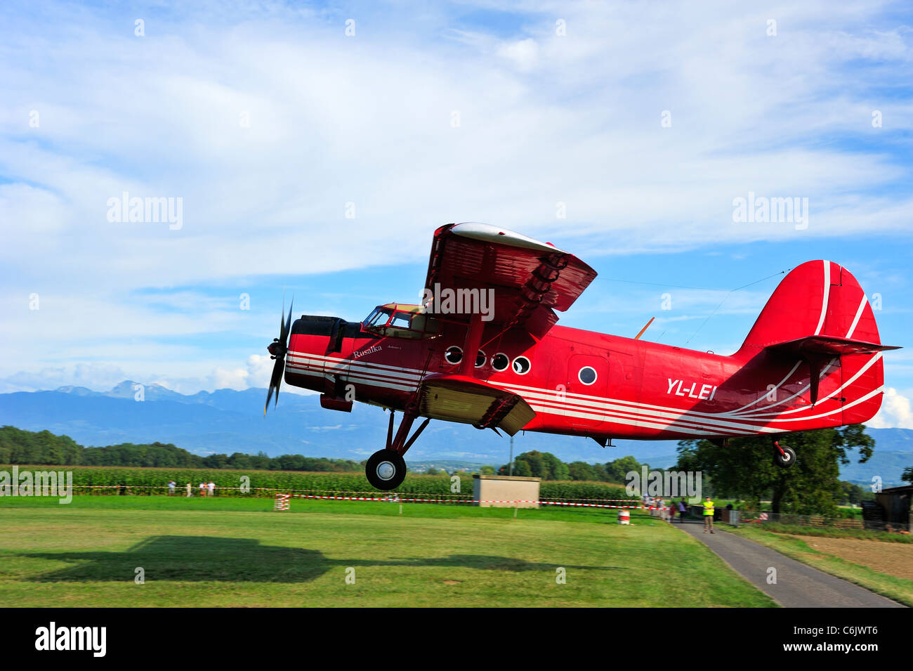 Un Antonov An-2 atterraggio biplanare. Sfocatura sullo sfondo. Spazio per il testo nel cielo. Foto Stock