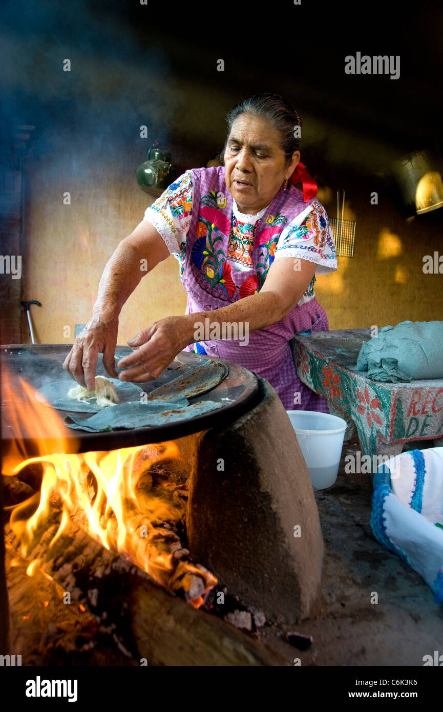 Donna con cottura blu tortilla di mais e formaggio Oaxaca, Messico Foto Stock