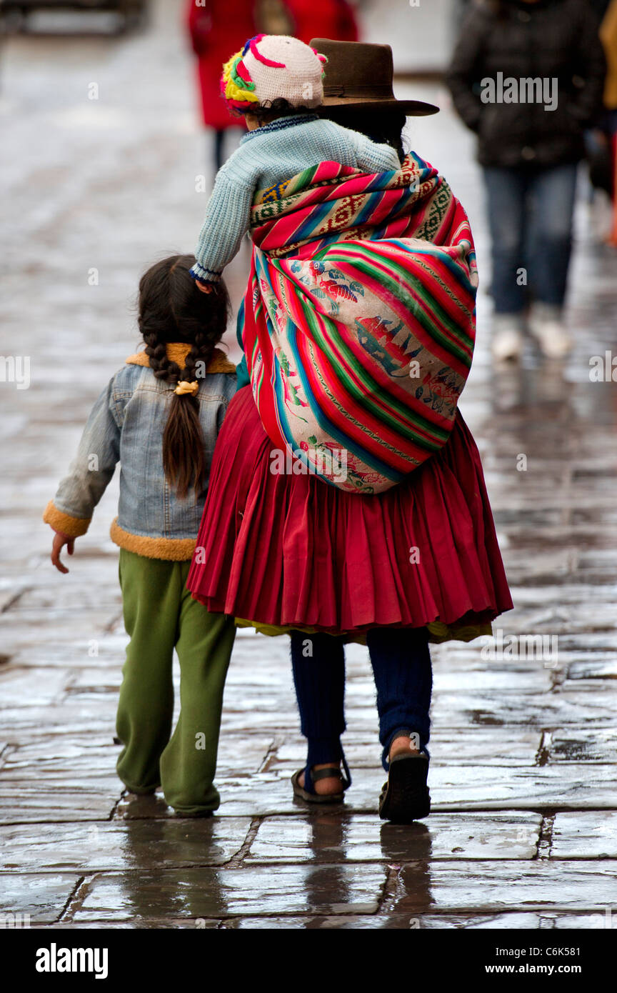 Famiglia Quechua camminando sulla strada, Cuzco, Perù Foto Stock