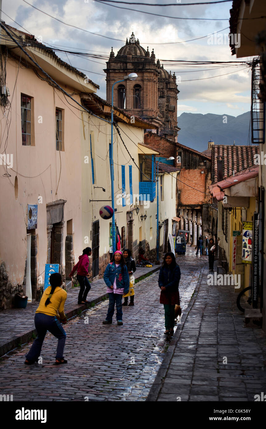 I bambini giocando a pallavolo su una strada bagnata, Cuzco, Perù Foto Stock