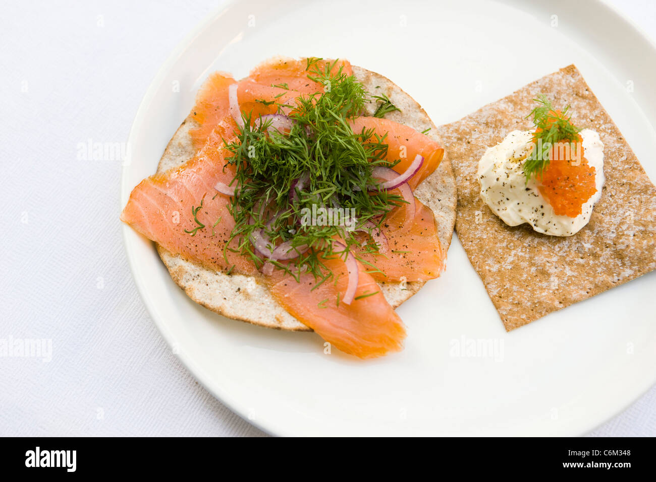 Pane fresco guarnita con salmone affumicato e aneto fresco, panna acida e uova di salmone Foto Stock