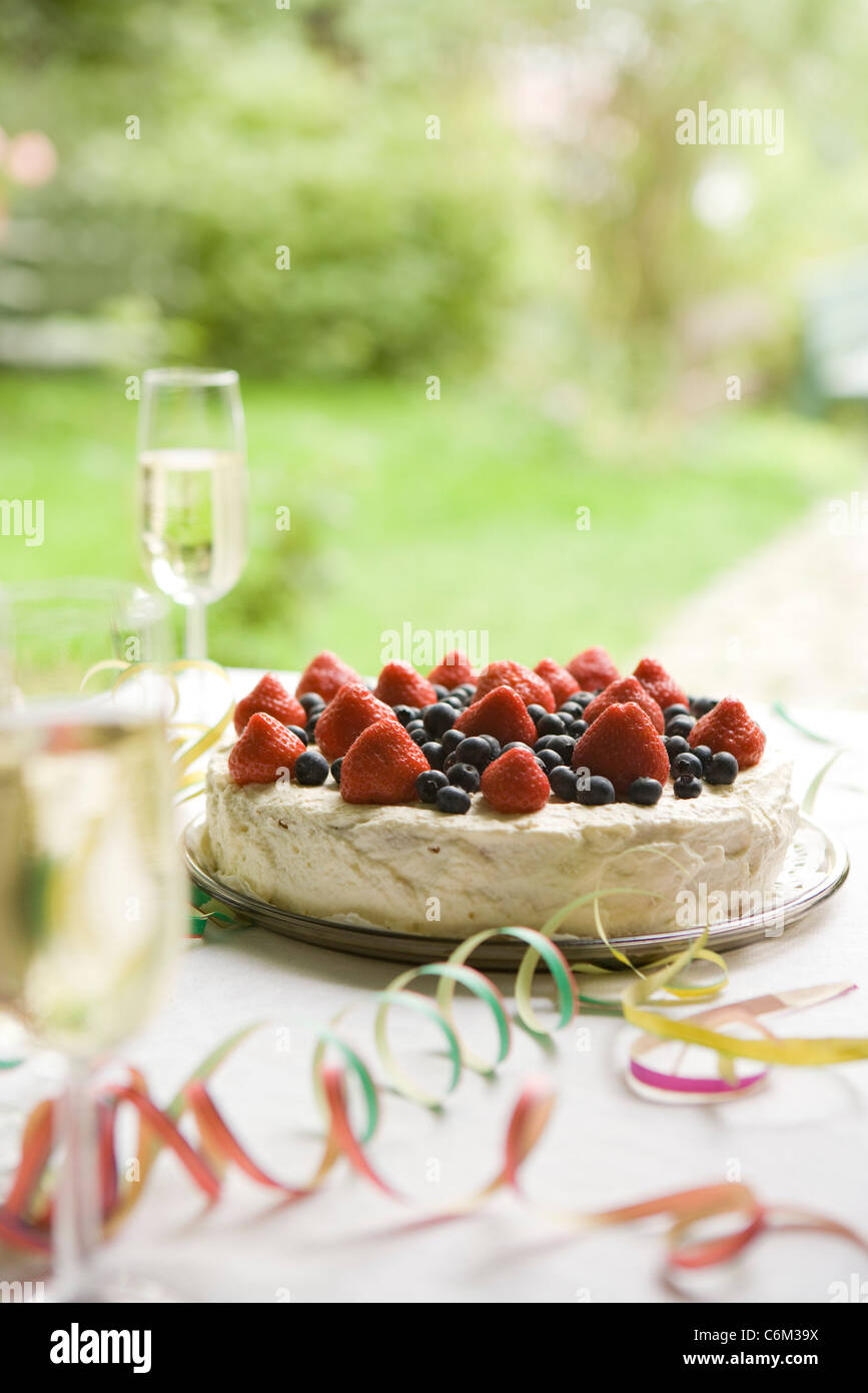 Mirtillo Fragola torta e champagne sulla tavola decorata con party streamers Foto Stock