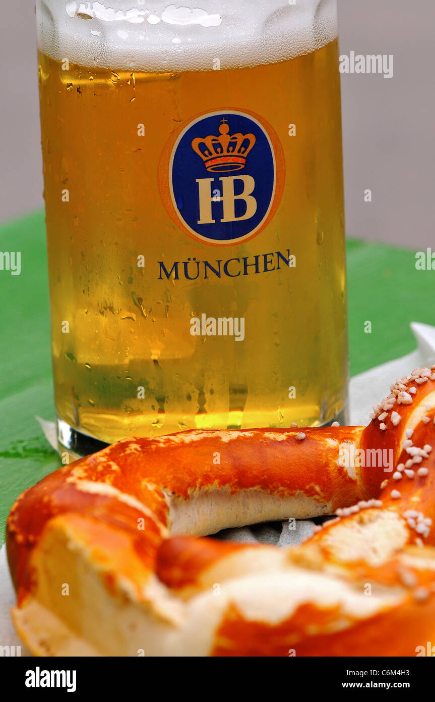 Birra e un pretzel alla Hofbrauhaus sala della birra, Monaco di Baviera, Germania Foto Stock