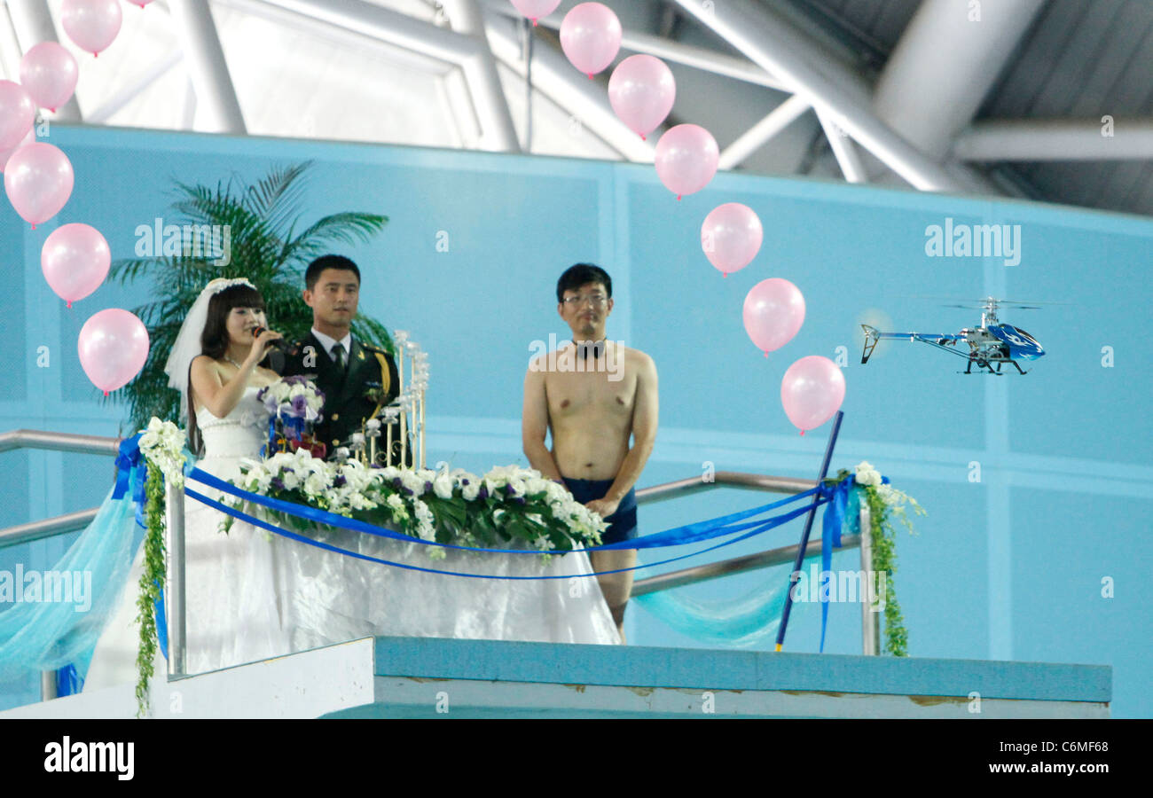 Giovane si sposi in una piscina una coppia felice celebrano le loro nozze collegando il nodo in una piscina in Nanjing, Cina. Foto Stock