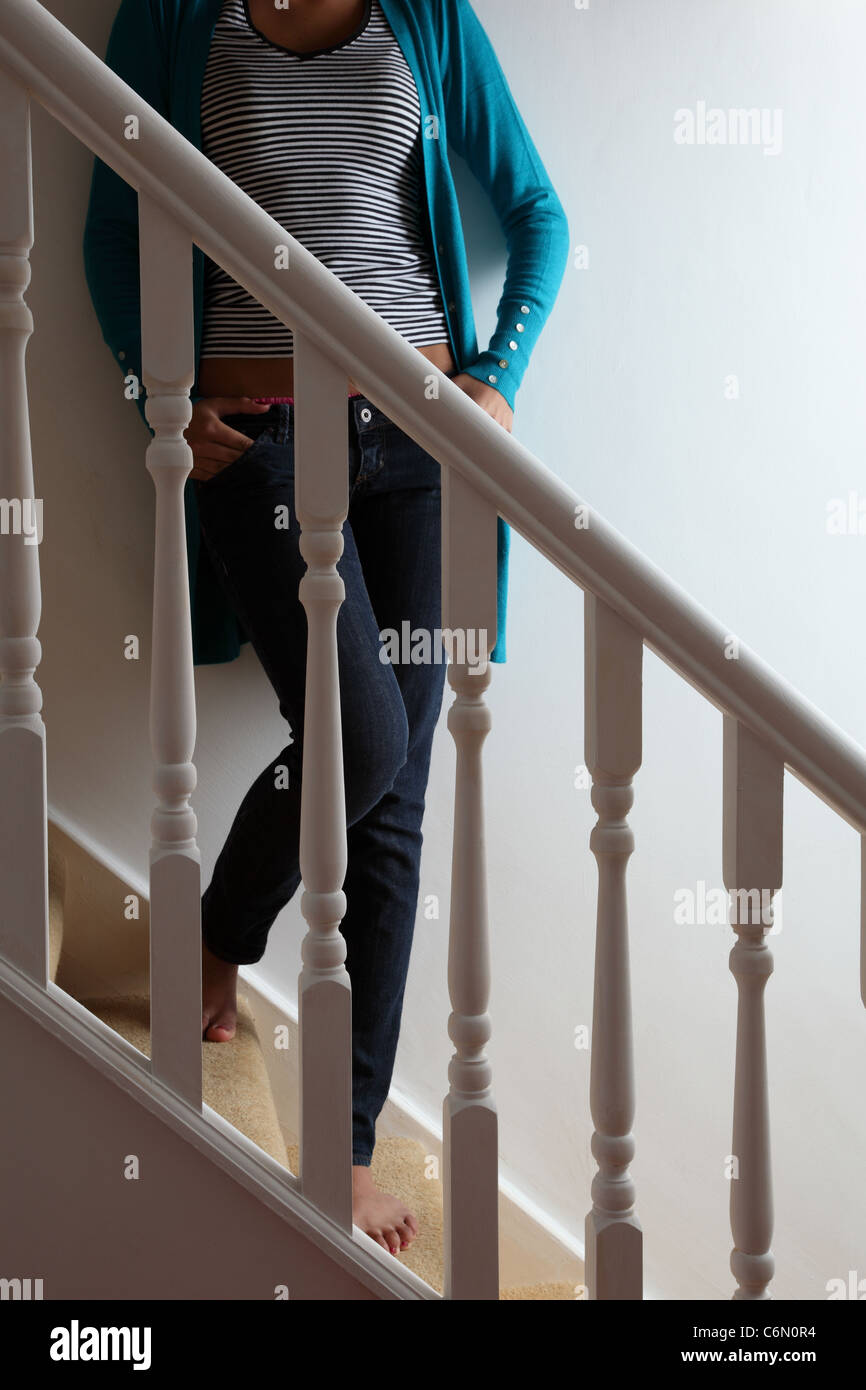 Anonimo donna in piedi sulle scale con le mani nelle sue tasche. Foto Stock