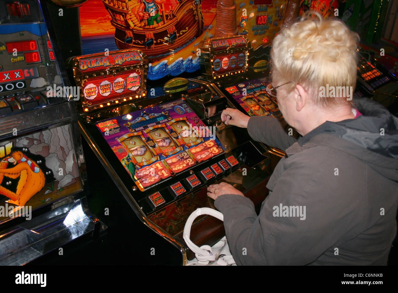 Donna che gioca slot machine. Foto Stock