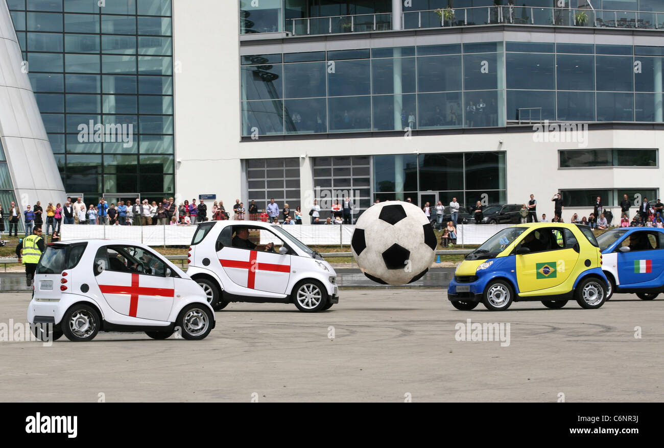 Smart Footie Inghilterra tiene sul resto del mondo come otto smart auto intrattenere la folla al Mercedes-Benz World durante il Foto Stock