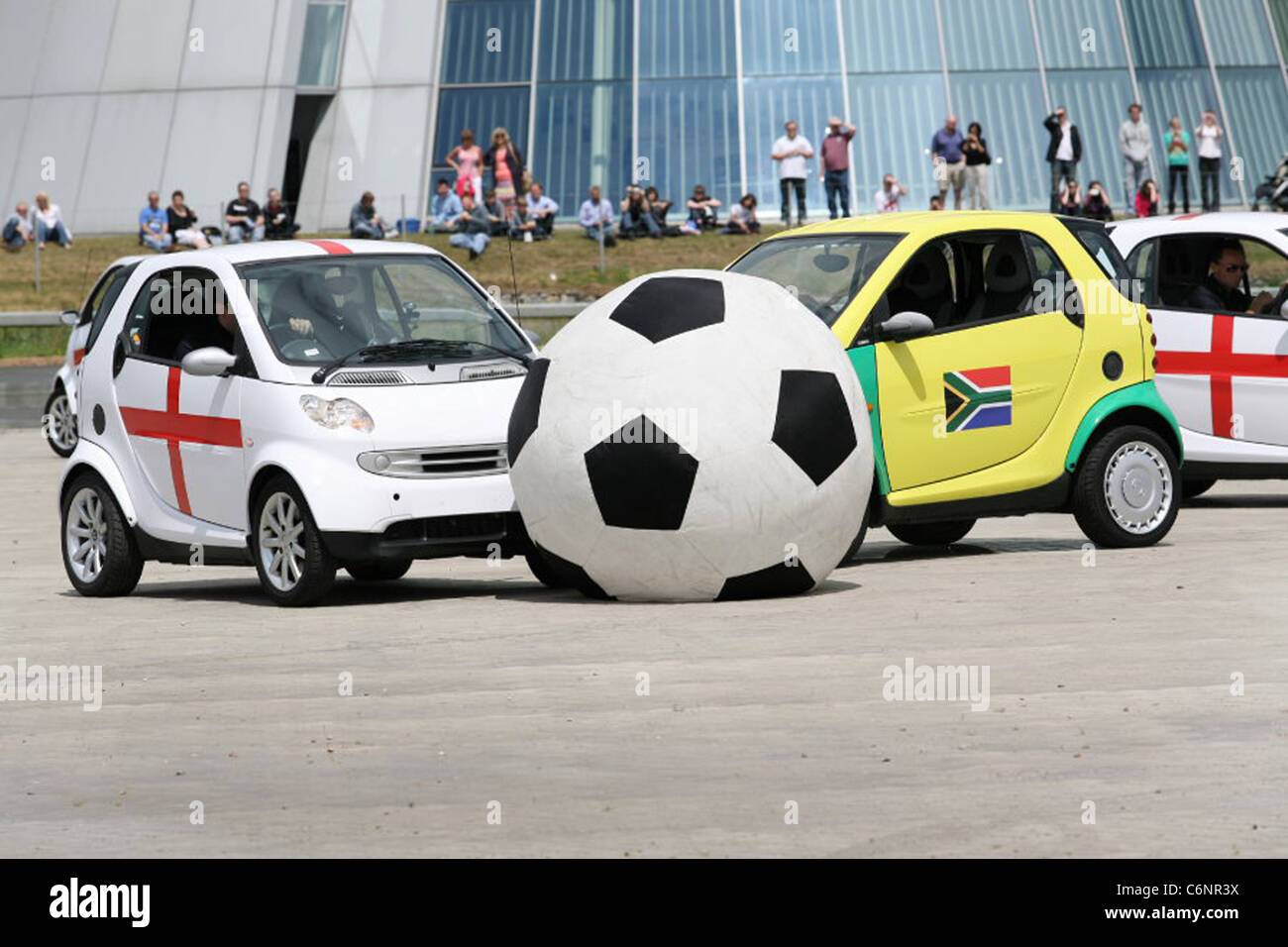 Smart Footie Inghilterra tiene sul resto del mondo come otto smart auto intrattenere la folla al Mercedes-Benz World durante il Foto Stock