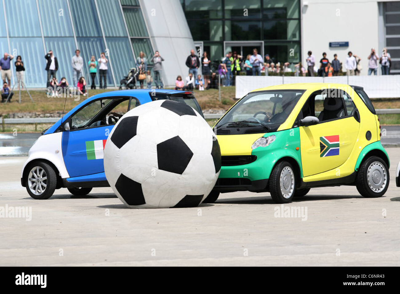 Smart Footie Inghilterra tiene sul resto del mondo come otto smart auto intrattenere la folla al Mercedes-Benz World durante il Foto Stock