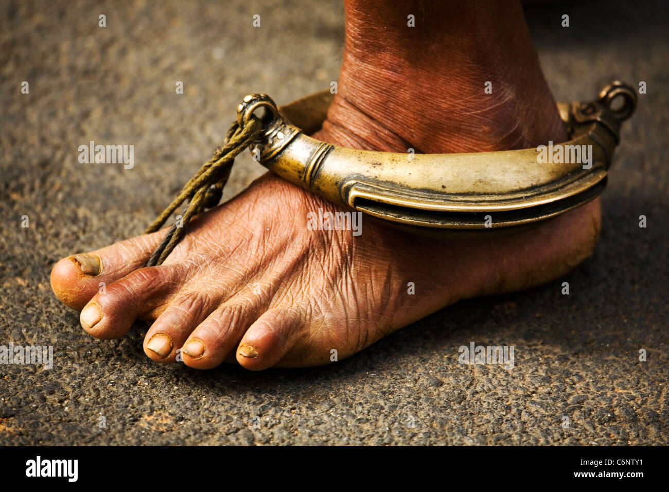 Il piede di un uomo indù indossando un oggetto in ottone sul suo piede a Trichur (Thrissur) in Kerala, India. Foto Stock