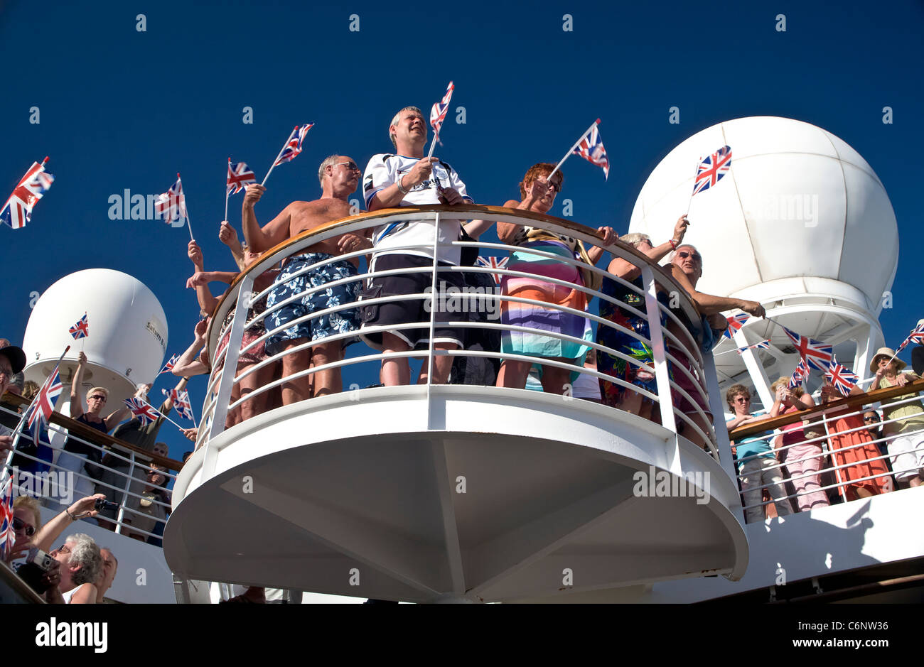 Crociera passeggeri sventolando Union Jack Flag. Foto Stock