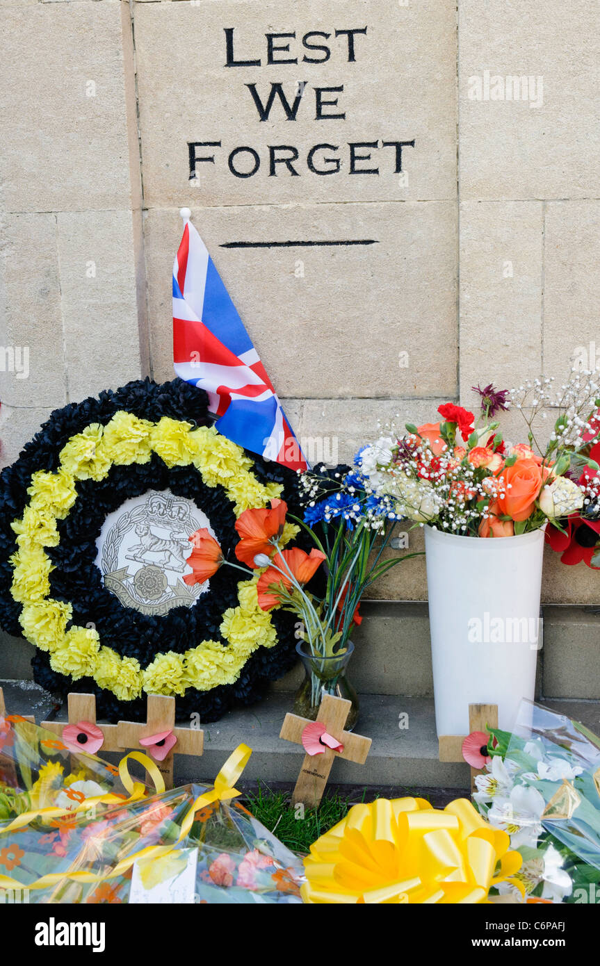 Le corone ed altri oggetti lasciati sul terreno intorno al Royal Wootton Bassett Memoriale di guerra. Foto Stock
