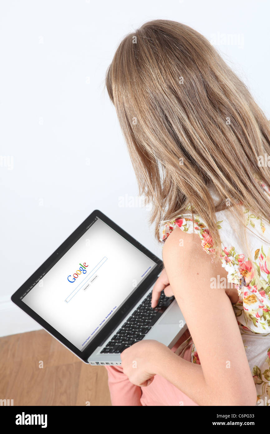 Vista da sopra del giovane femmina usando un computer portatile - Google. Foto Stock