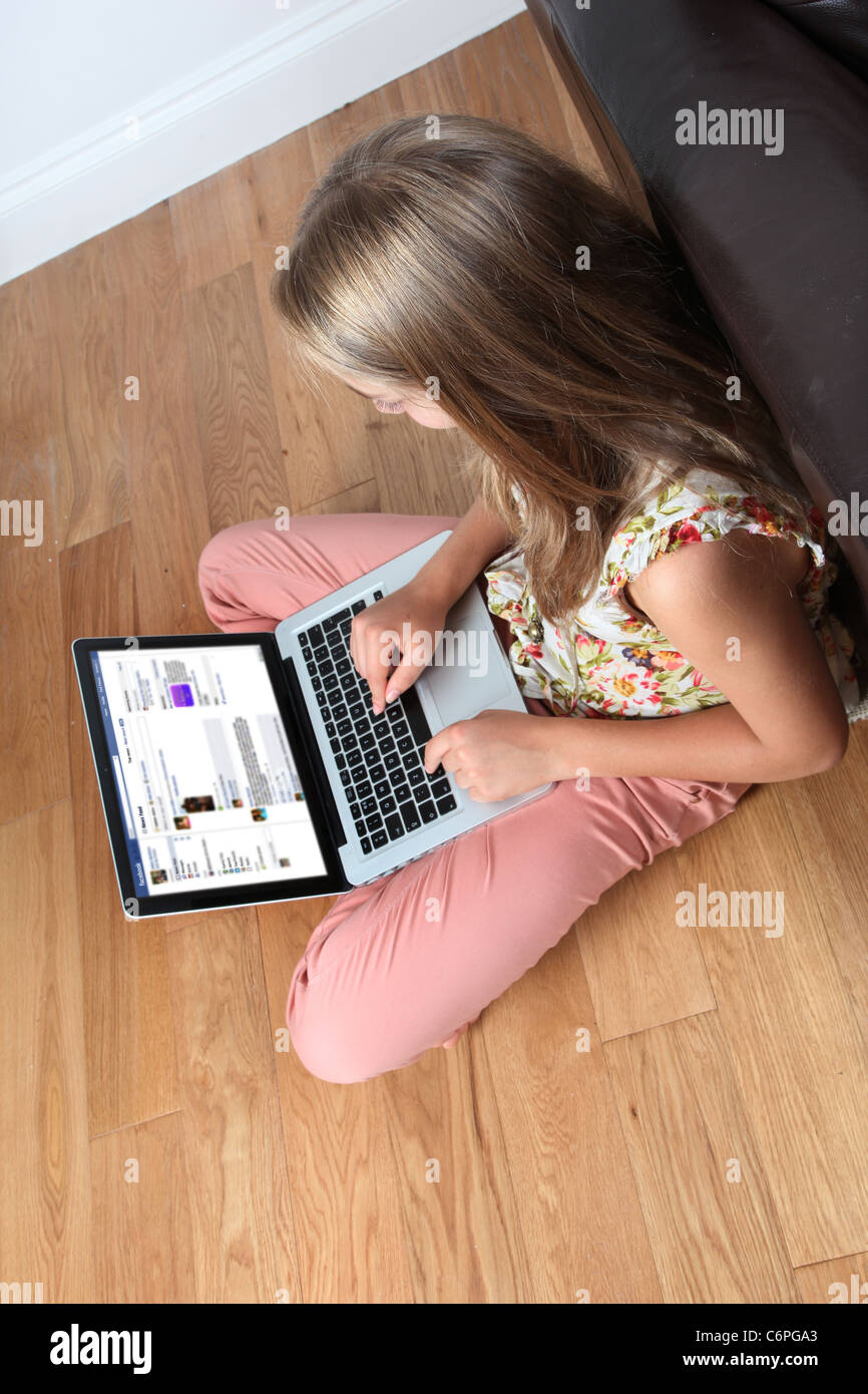 Vista da sopra del giovane femmina usando un computer portatile su una rete sociale pagina. Foto Stock