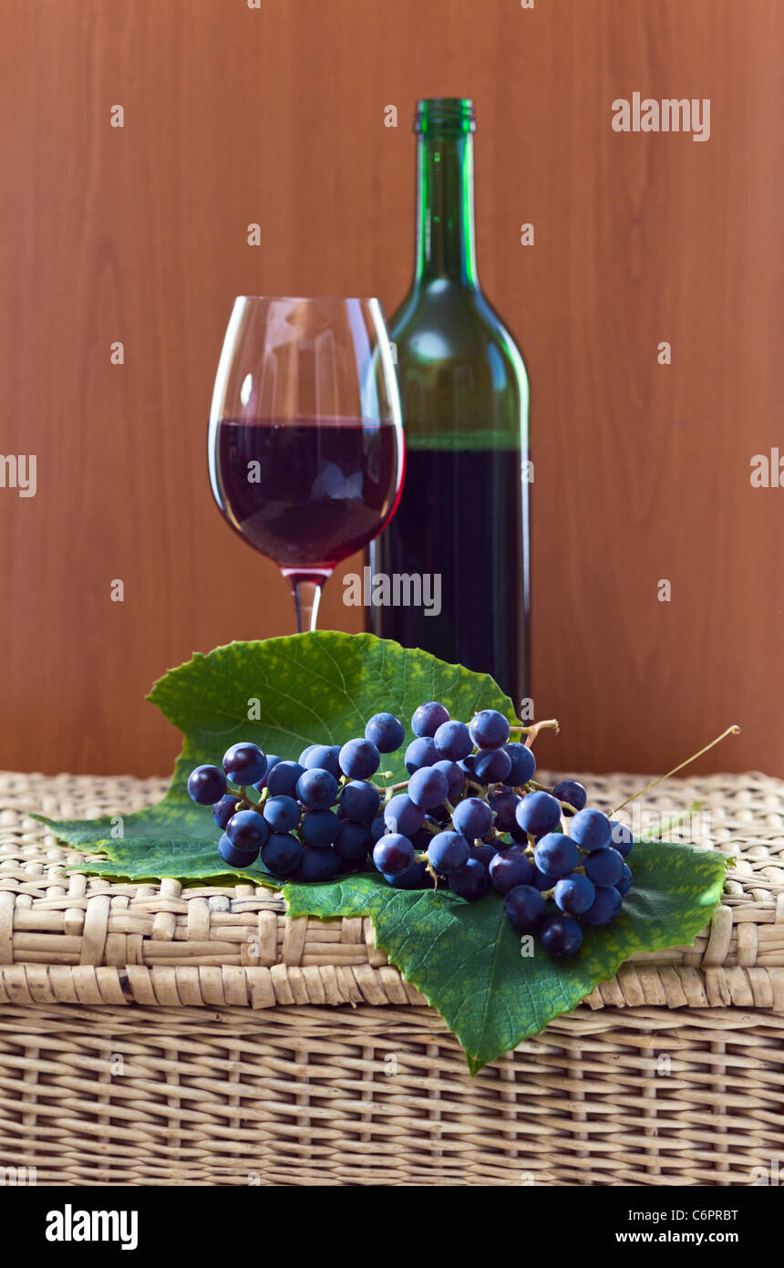 Uva e vino rosso su una tabella wattled. Foto Stock