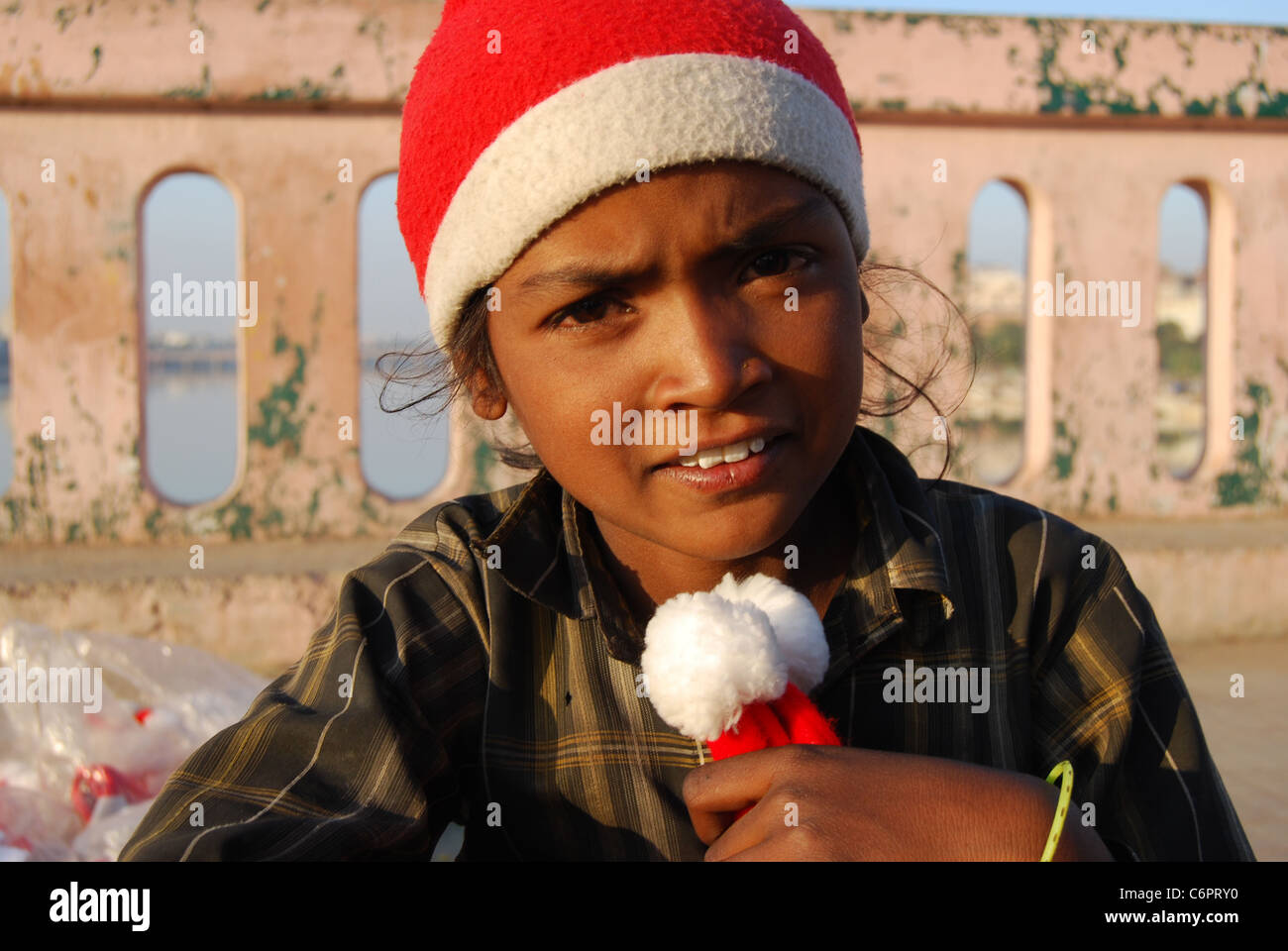 Una ragazza povera è la vendita di Santa Claus caps al tempo di Natale (India) Foto Stock