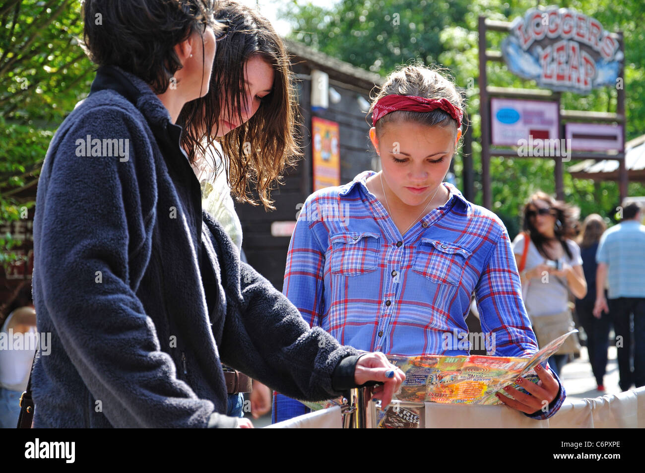 Ragazze guardando park map, Thorpe Park Theme Park, Chertsey, Surrey, England, Regno Unito Foto Stock