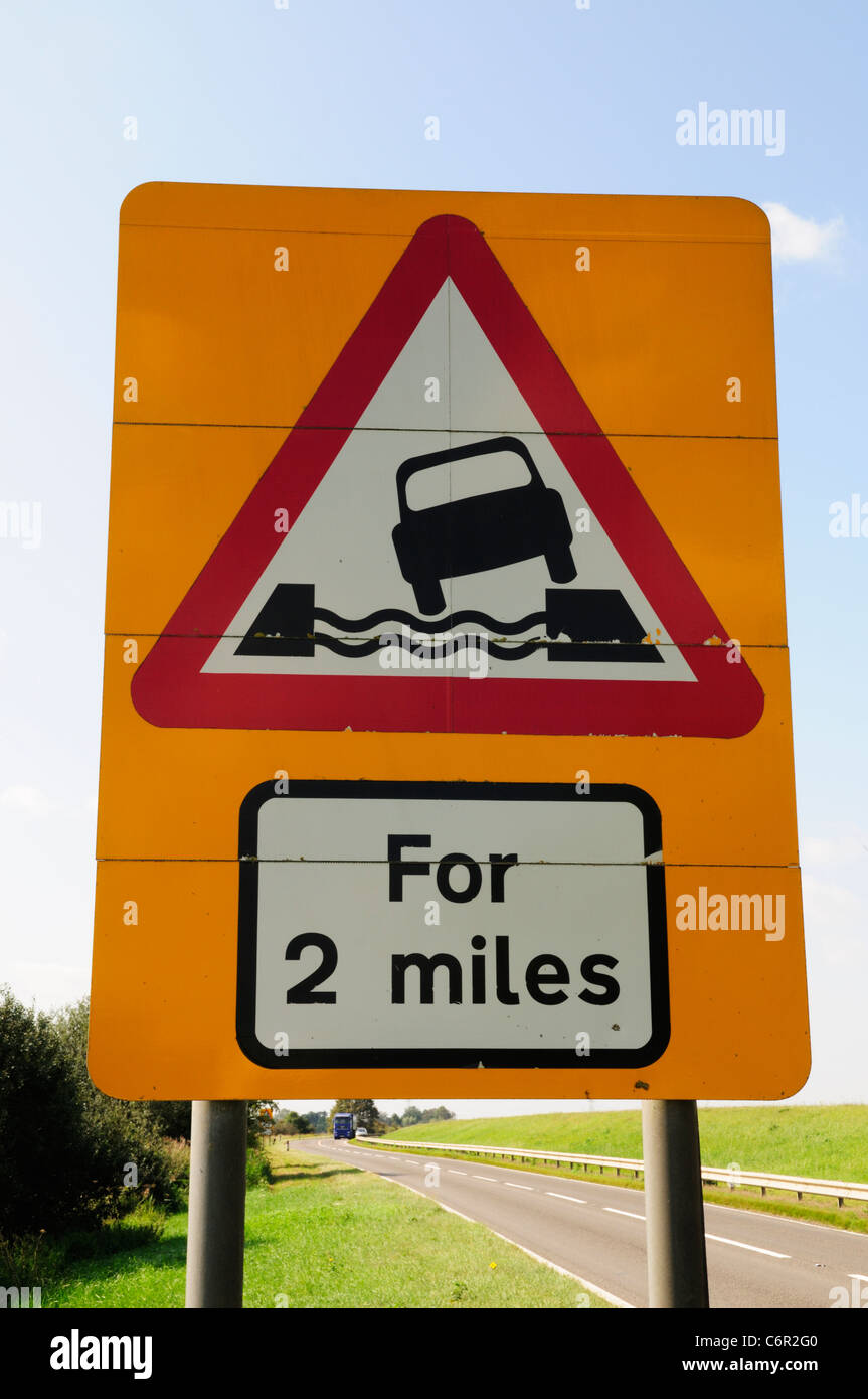 Corso d'acqua a fianco di strada per 2 miglia cartello stradale, dieci miglia di banca, vicino Littleport, Cambridgeshire, England, Regno Unito Foto Stock