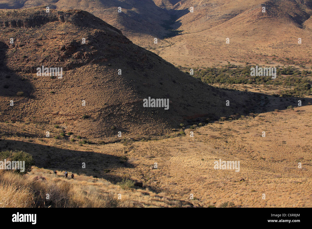Gli escursionisti sopraffatte da massicce hill nel paesaggio del deserto Foto Stock