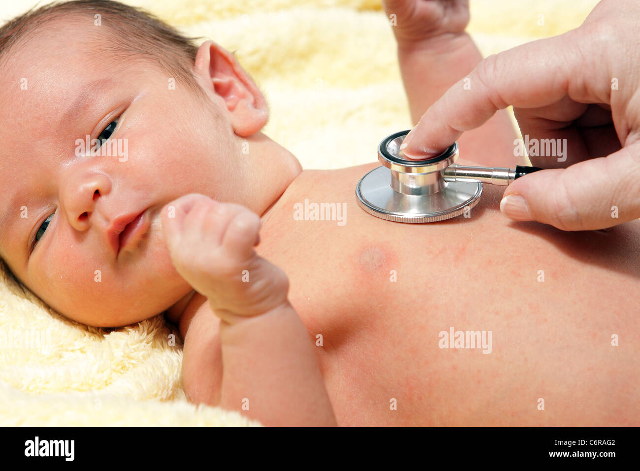 Uno stetoscopio in ascolto ad un bambino del battito cardiaco Foto Stock