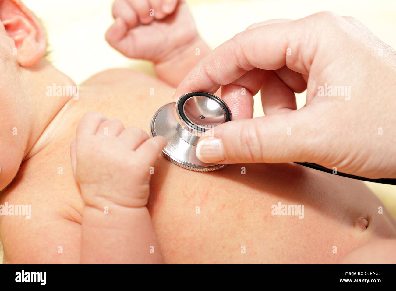 Uno stetoscopio in ascolto ad un bambino del battito cardiaco Foto Stock