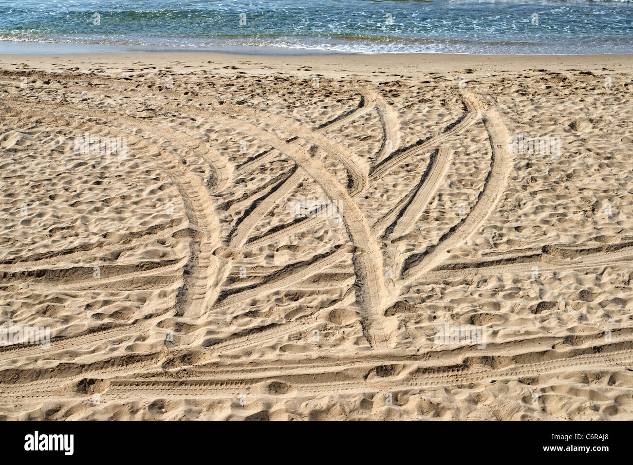 Tracce di pneumatici su di una spiaggia di sabbia Foto Stock