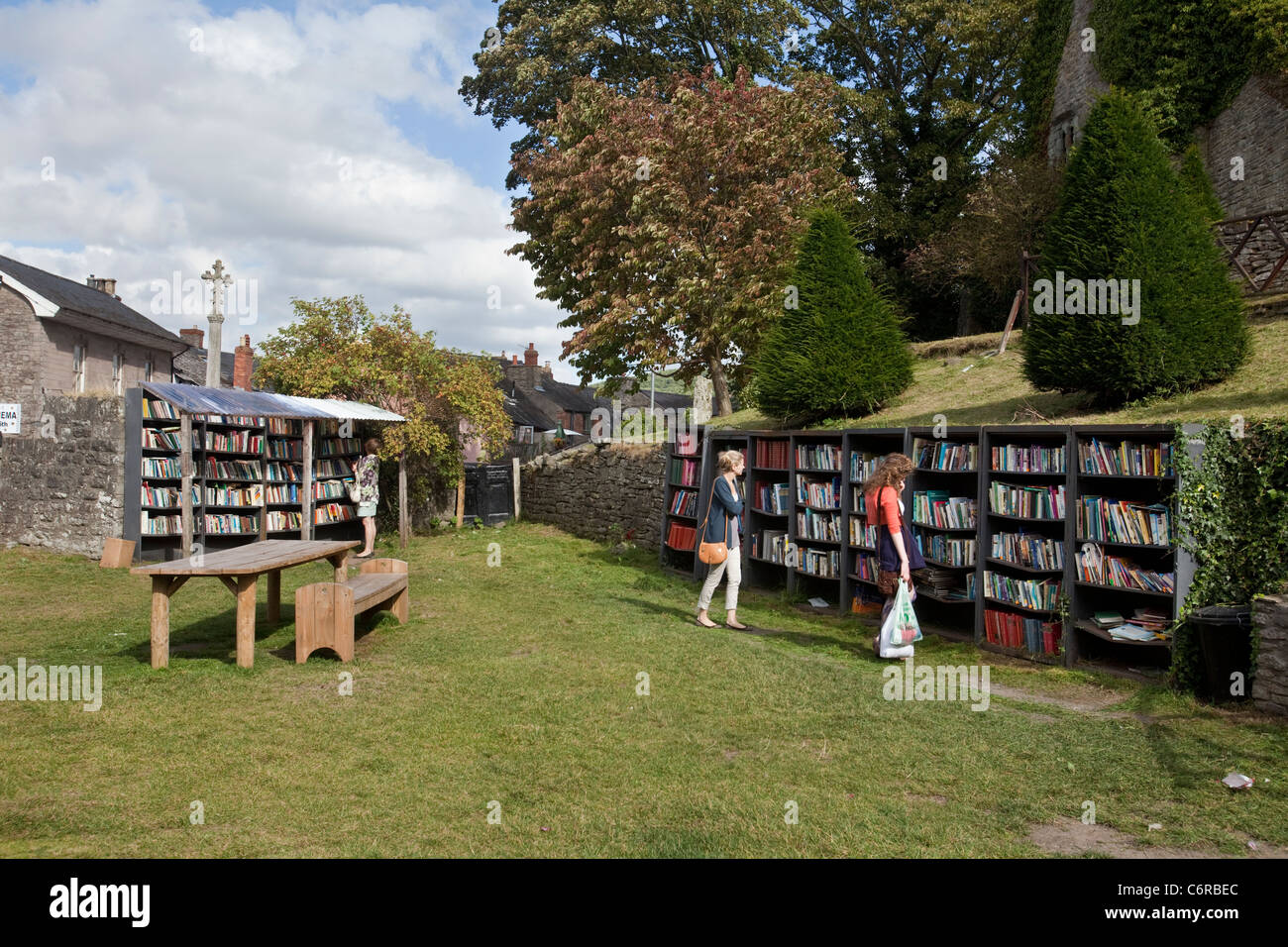 Due persone navigando in un bookshop onestà nel parco del castello di fieno in Hay-On-Wye, Regno Unito Foto Stock